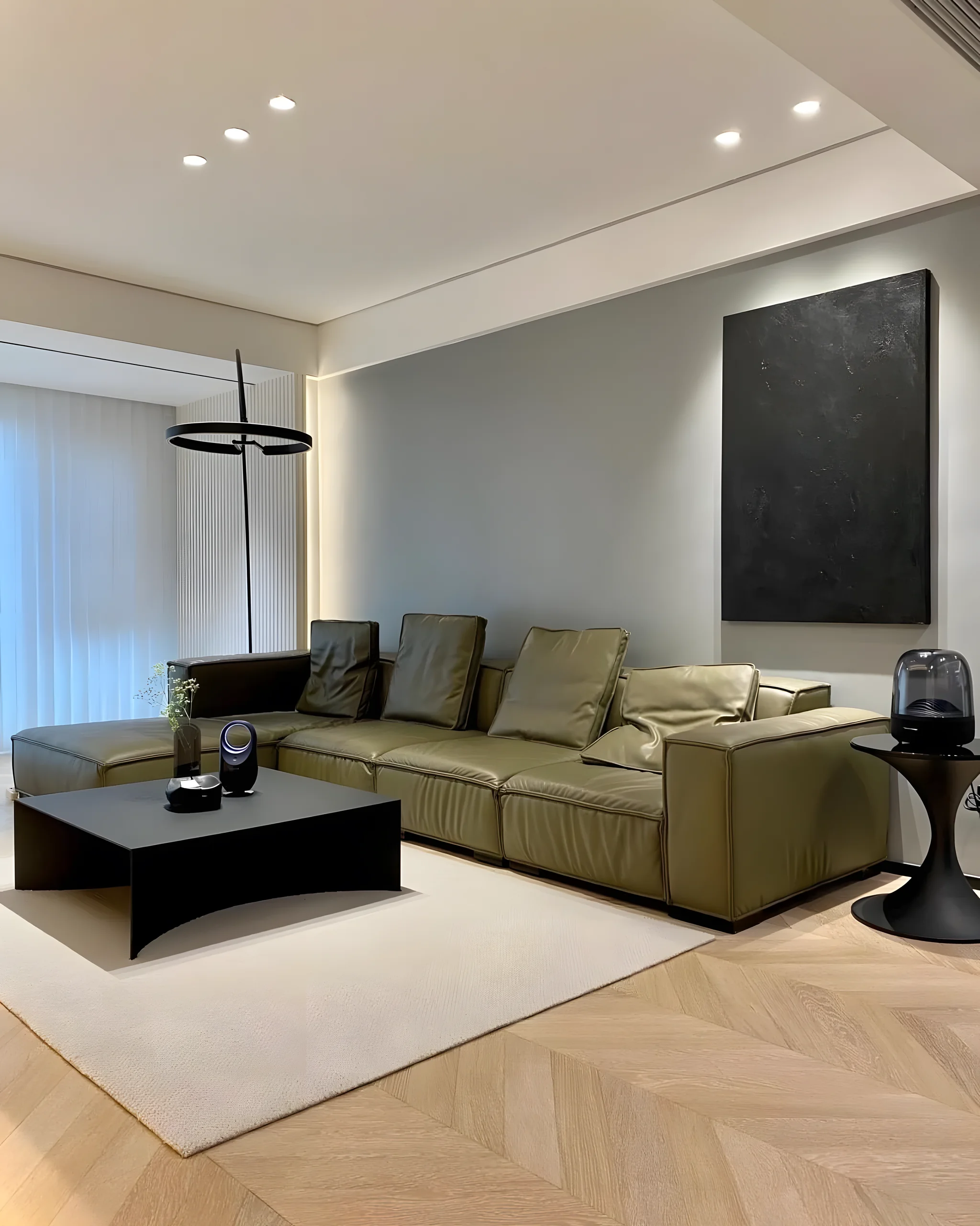 Condo living room with olive green sofa and herringbone floor